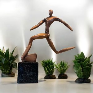 Fotbollsstatyett figur sparkar boll bronsfärgad på sockel